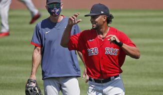 Boston Red Sox&#39;s Xander Bogaerts, right, runs past Interim Manager Ron Roenicke during baseball training camp at Fenway Park, Tuesday, July 7, 2020, in Boston. (AP Photo/Elise Amendola)