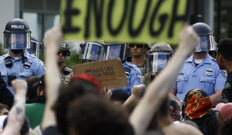In this June 1, 2020, file photo, protesters rally as Philadelphia police officers and Pennsylvania National Guard soldiers look on in Philadelphia, over the death of George Floyd, a Black man who was in police custody in Minneapolis. (AP Photo/Matt Slocum, File)
