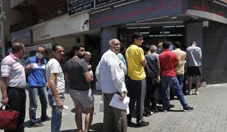 People line up outside an exchange shop to buy U.S. dollars, in Beirut, Lebanon, June 17, 2020. Lebanon&#39;s financial meltdown has thrown its people into a frantic search for dollars as the local currency&#39;s value evaporates. Long, raucous lines mass outside exchange bureaus to buy rationed dollars. Many try to rescue their dollars trapped in bank accounts frozen by the government. With tens of thousands thrown into poverty, the turmoil is fueling bitterness at banks and politicians. (AP Photo/Hussein Malla)