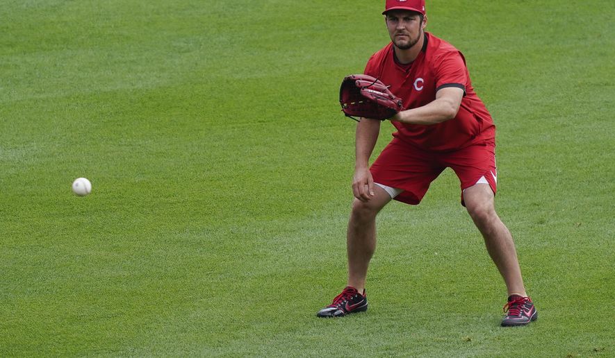 Cincinnati Reds pitcher Trevor Bauer warms up in the outfield during team baseball practice at Great American Ballpark in Cincinnati, Wednesday, July 8, 2020. (AP Photo/Bryan Woolston)