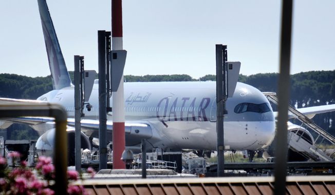 A Qatar Airways aircraft is parked at Rome&#x27;s Leonardo Da Vinci international airport, Wednesday, July 8, 2020. Rome airport authorities have refused to let 112 Bangladeshi passengers off a plane that landed from Qatar as Italy tightens restrictions on people arriving from coronavirus hotspots. The 112 Bangladeshis were among 205 passengers who arrived Wednesday aboard a Qatar Airways flight that originated in Pakistan and stopped in Doha, Qatar. (Mauro Scrobogna/LaPresse via AP)