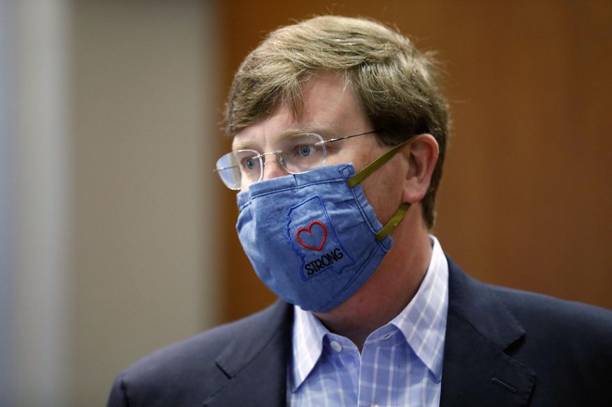 Gov. Tate Reeves sports a "Mississippi Strong" face mask following his coronavirus news briefing in Jackson, Miss., Wednesday, July 8, 2020. Reeves and other state officials provided reporters an update on the coronavirus and the state's ongoing strategy to limit transmission. (AP Photo/Rogelio V. Solis)