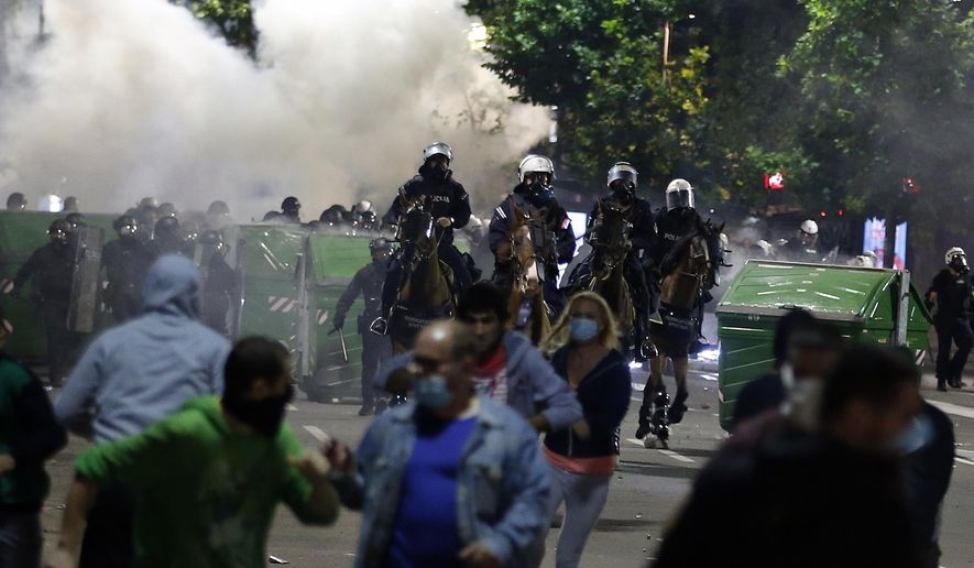 Sebian police officers disperse protesters in front of Serbian parliament building in Belgrade, Serbia, Wednesday, July 8, 2020. Thousands of people protested the Serbian president&#39;s announcement that a lockdown will be reintroduced after the Balkan country reported its highest single-day death toll from the coronavirus Tuesday. (AP Photo/Darko Vojinovic)