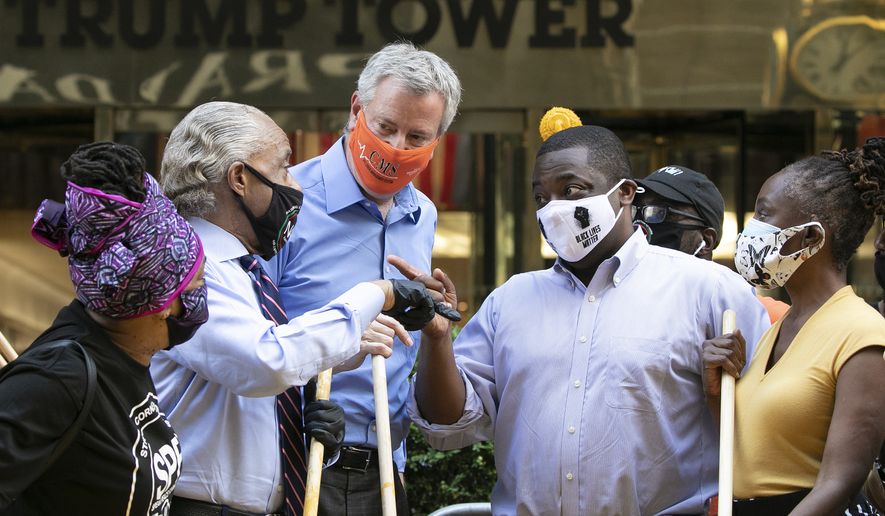 Mayor Bill de Blasio, center with orange mask, talks with Rev. Al Sharpton, second from left, while painting Black Lives Matter on Fifth Avenue in front of Trump Tower, Thursday, July 9, 2020, in New York. The mayor&#39;s wife, Chirlane McCray, is on the right. The others are unidentified. (AP Photo/Mark Lennihan)