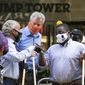 Mayor Bill de Blasio, center with orange mask, talks with Rev. Al Sharpton, second from left, while painting Black Lives Matter on Fifth Avenue in front of Trump Tower, Thursday, July 9, 2020, in New York. The mayor's wife, Chirlane McCray, is on the right. The others are unidentified. (AP Photo/Mark Lennihan)