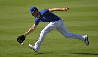 Los Angeles Dodgers center fielder Cody Bellinger fields a ball during the restart of baseball spring training Friday, July 3, 2020, in Los Angeles. (AP Photo/Mark J. Terrill)
