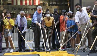 Mayor Bill de Blasio, third from left, participates in painting Black Lives Matter on Fifth Avenue in front of Trump Tower, Thursday, July 9, 2020, in New York. The mayor&#x27;s wife, Chirlane McCray, is fourth from left and Rev. Al Sharpton is second from left. (AP Photo/Mark Lennihan)