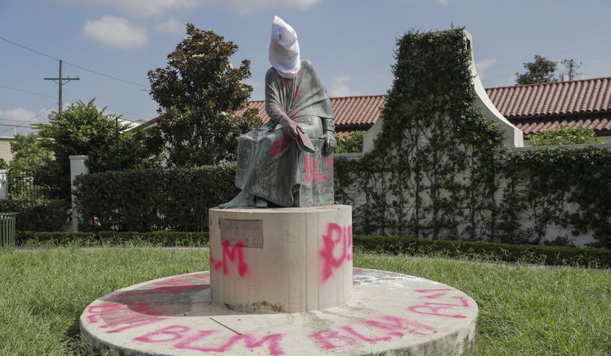 The monument of Sophie B. Wright near the intersection of Magazine and St. Andrews streets was vandalized in New Orleans, Friday, July 10, 2020. At least two statues of prominent historical figures were pulled from their pedestals in New Orleans and another has been covered with red spray paint, authorities said Friday. (David Grunfeld/The Advocate via AP)