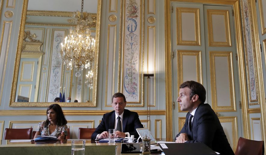 France&#39;s President Emmanuel Macron, right, attends a visio conference with Kosovo Prime Minister Avdullah Hoti, Serbian President Aleksandar Vucic, and German Chancellor Angela Merkel, at the Elysee Palace, in Paris, Friday, July 10, 2020. The leaders of Serbia and Kosovo will hold talks in Brussels on July 12, the first meeting between the two in long-stalled European Union-supervised negotiations aimed at normalizing relations, European Commission spokesman Peter Stano said Monday. (AP Photo/Christophe Ena, Pool)