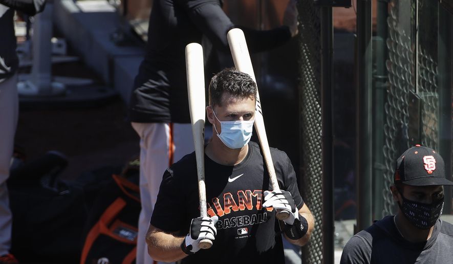 FILE - In this Sunday, July 5, 2020, file photo, San Francisco Giants' Buster Posey carries his bats during a baseball practice in San Francisco. Posey is the latest big-name player to skip this season because of concerns over the coronavirus pandemic. Posey announced his decision on Friday, July 10, 2020. He says his family finalized the adoption of identical twin girls this week. The babies were born prematurely and Posey said after consultations with his wife and doctor he decided to opt out of the season. (AP Photo/Jeff Chiu, File)
