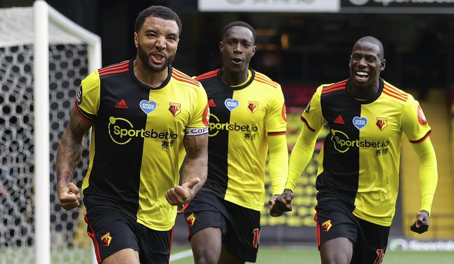 Watford's Troy Deeney, left, celebrates with teammates after scores his side's second goal from the penalty spot during the English Premier League soccer match between Watford and Newcastle at the Vicarage Road Stadium in Watford, England, Saturday, July 11, 2020. (Richard Heathcote/Pool via AP)