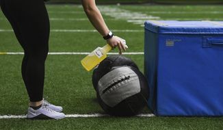 Workout equipment is sanitized after use during high school football workouts, Wednesday, July 8, 2020, at the Sanford Fieldhouse in Sioux Falls, S.D. (Erin Bormett/The Argus Leader via AP)
