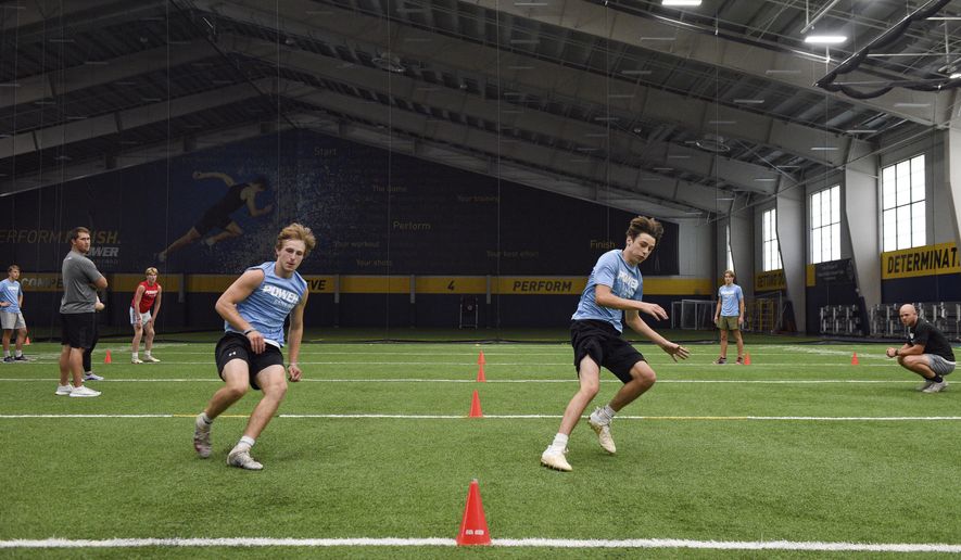 Lincoln High School football players race each other to base lines during a workout, Wednesday, July 8, 2020, at the Sanford Fieldhouse in Sioux Falls, S.D. (Erin Bormett/The Argus Leader via AP)