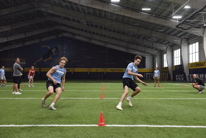 Lincoln High School football players race each other to base lines during a workout, Wednesday, July 8, 2020, at the Sanford Fieldhouse in Sioux Falls, S.D. (Erin Bormett/The Argus Leader via AP)