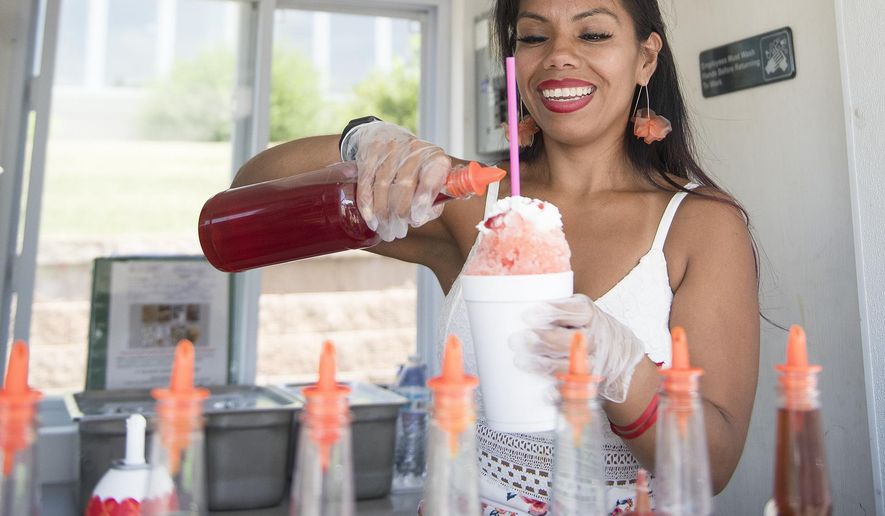 B-Lo Zero Sno Cones co-owner Emily Navarrete makes a snow cone inside the business's trailer in Albert Lea, Minn., Wednesday, July 1, 2020. (Colleen Harrison/The Albert Lea Tribune via AP)