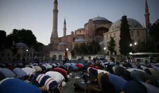 Muslims offer their evening prayers outside the Byzantine-era Hagia Sophia, one of Istanbul&#39;s main tourist attractions in the historic Sultanahmet district of Istanbul, following Turkey&#39;s Council of State&#39;s decision, Friday, July 10, 2020. Turkey&#39;s highest administrative court issued a ruling Friday that paves the way for the government to convert Hagia Sophia - a former cathedral-turned-mosque that now serves as a museum - back into a Muslim house of worship. The Council of State threw its weight behind a petition brought by a religious group and annulled a 1934 cabinet decision that changed the 6th century building into a museum.(AP Photo/Emrah Gurel)