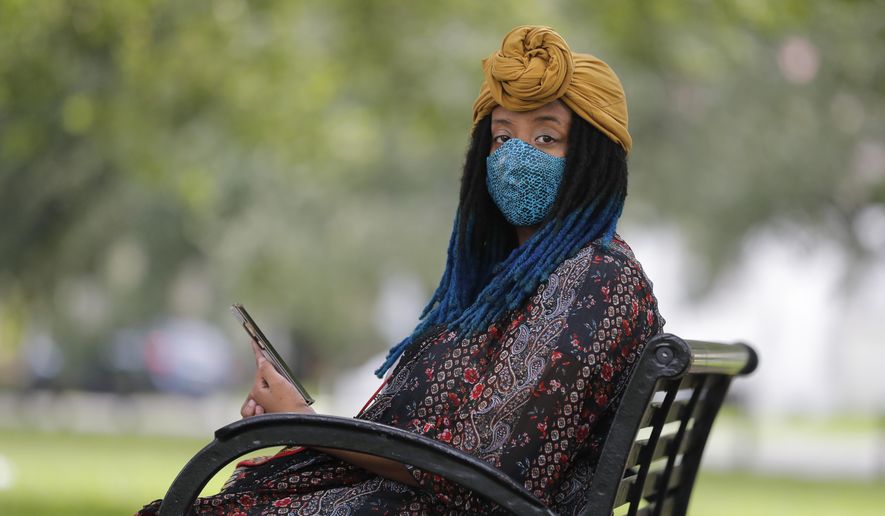 Jasmin Pierre poses for a photo with her smartphone app, in New Orleans, Thursday, July 2, 2020. Pierre, who survived multiple suicide attempts, doesn't want people struggling alone. She created The Safe Place, a free Black-oriented mental health app that's seen more signups during the pandemic. (AP Photo/Gerald Herbert)