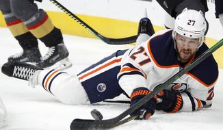 In this Feb. 26, 2020, file photo, Edmonton Oilers defenseman Mike Green (27) fights for the puck against the Vegas Golden Knights during the first period of an NHL hockey game in Las Vegas. Green and Vancouver’s Sven Baertschi are opting out. Dallas defenseman Roman Polak is not reporting for now. And Tampa Bay captain Steven Stamkos is not reporting at full strength. Green and Baertschi joined Calgary defender Travis Hamonic in choosing not to participating in the resumption of the NHL season. Green, like Hamonic, decided not to play for family reasons. (AP Photo/John Locher) ** FILE **