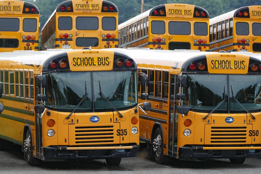 Rows of school buses are parked at their terminal, Friday, July 10, 2020, in Zelienople, Pa. Pennsylvania schools are working on how they will safely transport students this fall, but one idea that won't be part of the plan is to install plastic barriers around school bus drivers. The state Transportation Department rejected that idea recently, saying there wasn't evidence it'll make anyone safer. (AP Photo/Keith Srakocic)