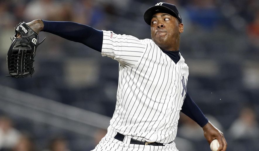 FILE - In this June 24, 2019, file photo, New York Yankees closer Aroldis Chapman winds up in the ninth inning of a baseball game against the Toronto Blue Jays in New York. Yankees manager Aaron Boone announced Saturday, July 11, 2020, that Chapman has tested positive for the coronavirus and is experiencing mild symptoms. (AP Photo/Kathy Willens, File)