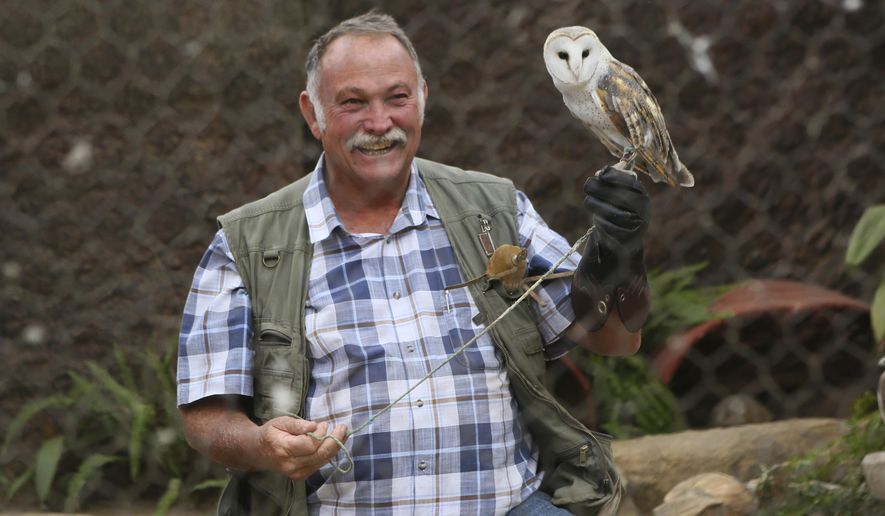 Gary Strafford, a Zimbabwean falconer, holds an owl inside one of the cages at his bird sanctuary, Kuimba Shiri, near Harare, Zimbabwe, Wednesday, June, 17, 2020. Kuimba Shiri, Zimbabwe&#x27;s only bird park, has survived tumultuous times, including violent land invasions and a devastating economic collapse. Now the outbreak of COVID-19 is proving a stern test. With Zimbabwe’s inflation currently at more than 750%, tourism establishments are battling a vicious economic downturn worsened by the new coronavirus travel restrictions. (AP Photo/Tsvangirayi Mukwazhi)