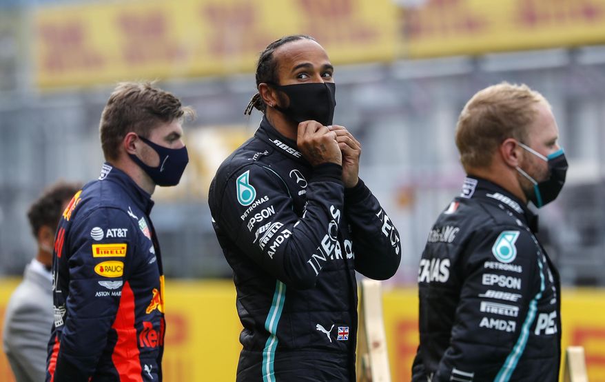 Mercedes driver Lewis Hamilton of Britain, center, stands on the podium after winning the Styrian Formula One Grand Prix race at the Red Bull Ring racetrack in Spielberg, Austria, Sunday, July 12, 2020. Third placed Red Bull driver Max Verstappen of the Netherlands on the left, second placed Mercedes driver Valtteri Bottas of Finland on the right. (Leonhard Foeger/Pool via AP)