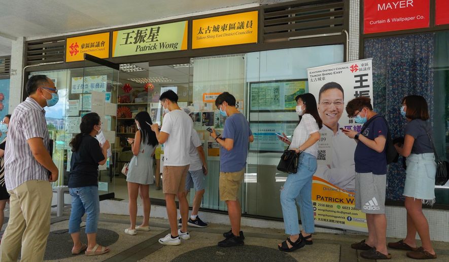 People queue up to vote in Hong Kong Sunday, July 12, 2020, in an unofficial primary for pro-democracy candidates ahead of legislative elections in September. Over 200,000 Hong Kongers voted in an unofficial Hong Kong primary that will help the pro-democracy camp decide which candidates to field in legislative elections in September. The turnout exceeded organizers' estimates that some 170,000 people would turn up to vote over the weekend. (AP Photo/Vincent Yu)