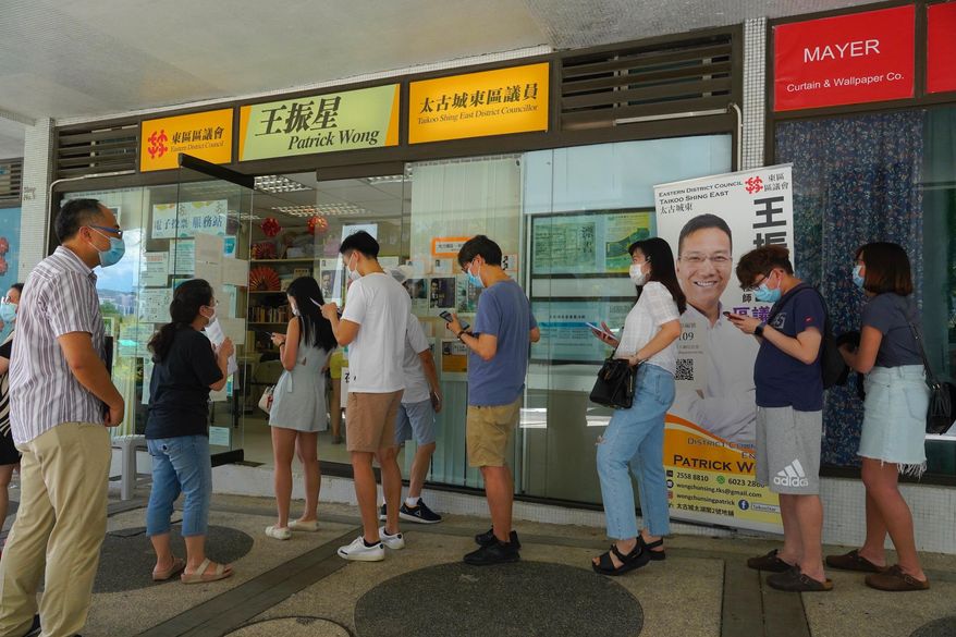 People queue up to vote in Hong Kong Sunday, July 12, 2020, in an unofficial primary for pro-democracy candidates ahead of legislative elections in September. Over 200,000 Hong Kongers voted in an unofficial Hong Kong primary that will help the pro-democracy camp decide which candidates to field in legislative elections in September. The turnout exceeded organizers' estimates that some 170,000 people would turn up to vote over the weekend. (AP Photo/Vincent Yu)