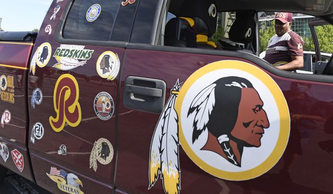 Rodney Johnson of Chesapeake, Va., stands with his truck outside FedEx Field in Landover, Md., Monday, July 13, 2020. The Washington NFL franchise announced Monday that it will drop the &quot;Redskins&quot; name and Indian head logo immediately, bowing to decades of criticism that they are offensive to Native Americans. (AP Photo/Susan Walsh)
