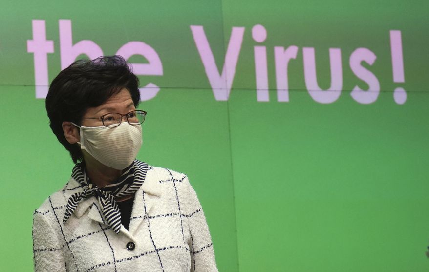 Hong Kong Chief Executive Carrie Lam arrives at a press conference in Hong Kong, Monday, July 13, 2020. Hong Kong on Monday introduced more stringent social-distancing measures, banning public gatherings of more than four and making it compulsory to wear a mask on public transport as the city battles a fresh outbreak of locally transmitted coronavirus infections. (AP Photo/Vincent Yu)