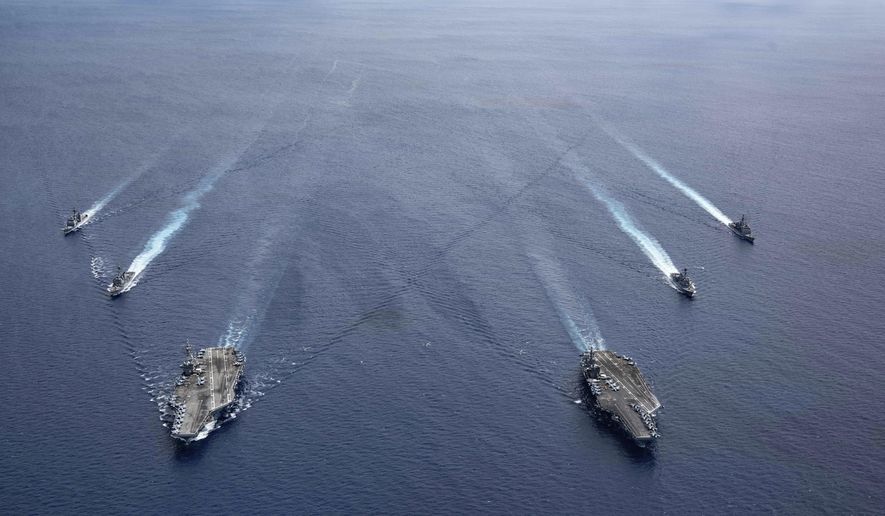 In this photo provided by U.S. Navy, the USS Ronald Reagan (CVN 76) and USS Nimitz (CVN 68) Carrier Strike Groups steam in formation, in the South China Sea, Monday, July 6, 2020. China on Monday, July 6, accused the U.S. of flexing its military muscles in the South China Sea by conducting joint exercises with two U.S. aircraft carrier groups in the strategic waterway.(Mass Communication Specialist 3rd Class Jason Tarleton/U.S. Navy via AP) ** FILE **