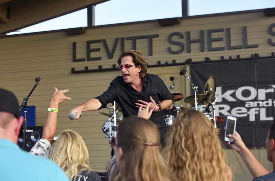 Kory Van Sickle, of Kory and the Fireflies, lets a fan sing into the microphone during the band's performance at Levitt at the Falls, Saturday, Aug. 10, 2019, in Sioux Falls, S.D. Advocacy work by the recently formed National Independent Venue Association is looking to remedy some of the problems faced by independent venue operators by asking leadership in Washington D.C. approve federal aid. (Erin Bormett/The Argus Leader via AP)