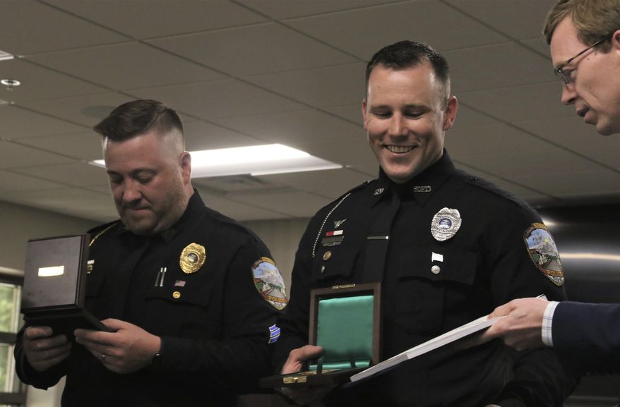 Sgts. Christopher Schmoker and Dylan Goetsch receive Congressional Records along with their Carnegie Medals from Rep. Dusty Johnson on Thursday, July 9, 2020, in the Sturgis City Council chambers. Schmoker and Goetsch pulled a 47-year-old man from a burning house in May 2018. (Siandhara Bonnet/Rapid City Journal via AP)