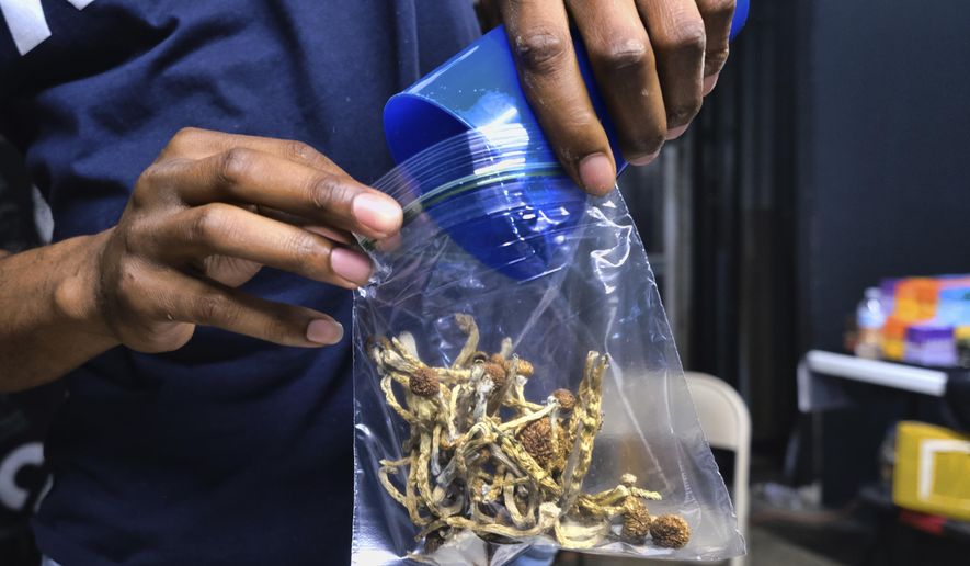 In this May 24, 2019, file photo a vendor bags psilocybin mushrooms at a pop-up cannabis market in Los Angeles. Despite pandemic conditions that made normal signature-gathering almost impossible, activists in the nation&#39;s capital say they have enough signatures for a November ballot initiative that would decriminalize natural psychedelics such as mescaline and psilocybin mushrooms. (AP Photo/Richard Vogel, File)