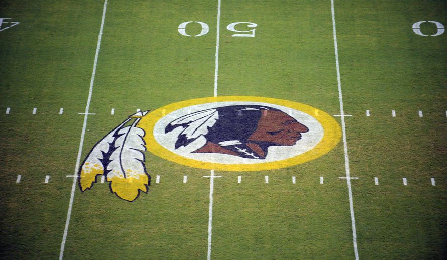 In this Aug. 28, 2009 file photo, the Washington Redskins logo is shown on the field before the start of a preseason NFL football game against the New England Patriots in Landover, Md.  The Washington NFL franchise announced Monday that it will drop the “Redskins” name and Indian head logo immediately, bowing to decades of criticism that they are offensive to Native Americans.  (AP Photo/Nick Wass) ** FILE **