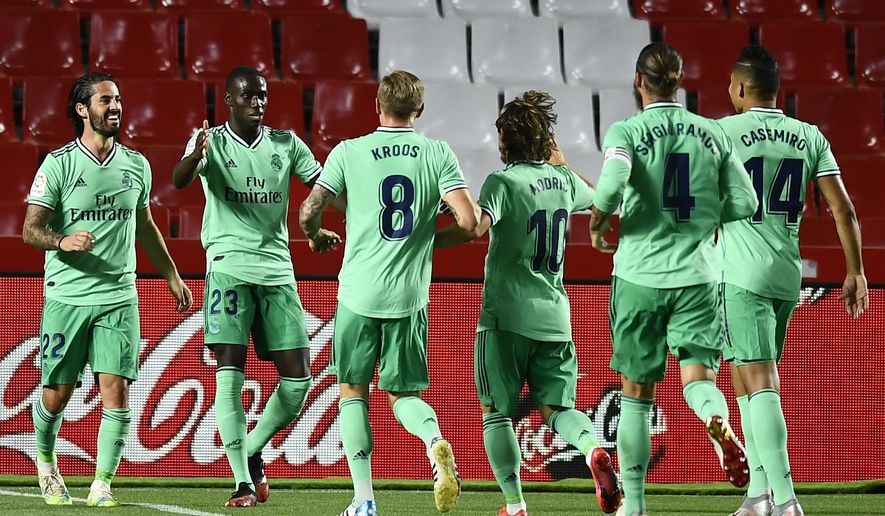 Real Madrid's Ferland Mendy, second left, celebrates after scoring with teammates the opening goal during the Spanish La Liga soccer match between Granada and Real Madrid at the Los Carmenes stadium in Granada, Spain, Monday, July 13, 2020. (AP Photo/Jose Breton)