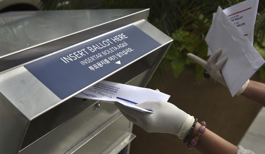 FILE - In this July 7, 2020, file photo a woman wearing gloves drops off a mail-in ballot at a drop box in Hackensack, N.J. The November election is coming with a big price tag as America faces the coronavirus pandemic. The demand for mail-in ballots is surging, election workers are in need of training and polling booths might have to be outfitted with protective shields. (AP Photo/Seth Wenig, File)