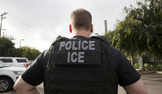 In this July 8, 2019, file photo, a U.S. Immigration and Customs Enforcement (ICE) officer looks on during an operation in Escondido, Calif. (AP Photo/Gregory Bull, File)  **FILE**