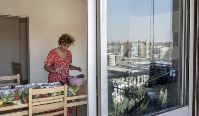 Basma Mostafa, a 30-year-old journalist who founded an initiative that sends freshly home cooked meals to quarantined coronavirus patients, package food at her friend's apartment, in Cairo, Egypt. Saturday, July 11, 2020.  Mostafa, who works with others to coordinate the volunteer effort, said she got the idea of helping out when she was going through a difficult time. "I thought that to alleviate my suffering, I can engage with the suffering of others and feel more for them," she said. "I derive my strength and perseverance from the patients." (AP Photo/Nariman El-Mofty)