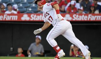 FILE - In this July 27, 2019, file photo, Los Angeles Angels&#39; Mike Trout runs to first while watching his two-run home run during the first inning of the team&#39;s baseball game against the Baltimore Orioles in Anaheim, Calif. (AP Photo/Mark J. Terrill, File)