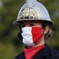 A firefighter wears a face mask with the colors of the French flag, prior to the Bastille Day parade Tuesday, July 14, 2020 on the Champs Elysees avenue in Paris. France are honoring nurses, ambulance drivers, supermarket cashiers and others on its biggest national holiday Tuesday. Bastille Day&#x27;s usual grandiose military parade in Paris is being redesigned this year to celebrate heroes of the coronavirus pandemic. (AP Photo/Christophe Ena, Pool)