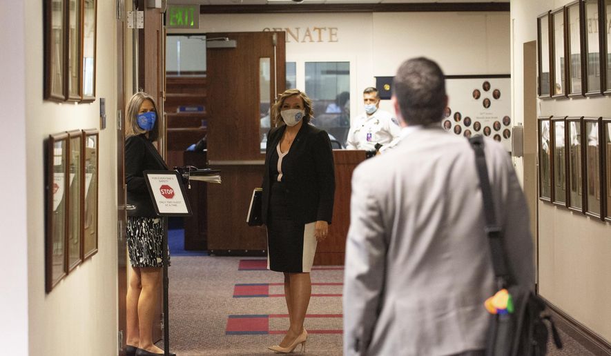 Nevada Assemblyman Steve Yeager, right calls out to state Sens. Julia Ratti, left, and Nicole Cannizzaro, in the hallway outside the Senate chambers on the sixth day of the 31st Special Session of the Nevada Legislature in Carson City, Nev., Tuesday, July 14, 2020. (David Calvert/The Nevada Independent via AP, Pool)