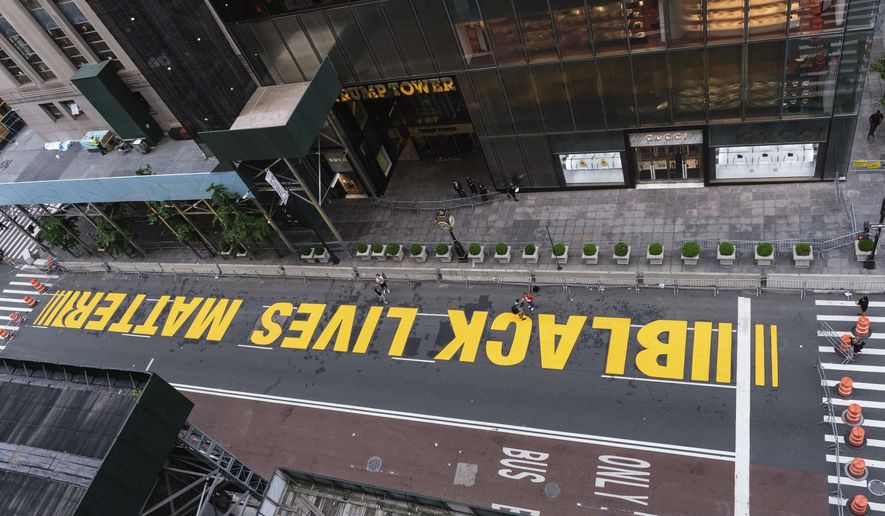Pedestrians walk on a Black Lives Matter mural painted in front of Trump Tower, Friday, July 10, 2020, in New York. (AP Photo/Yuki Iwamura)