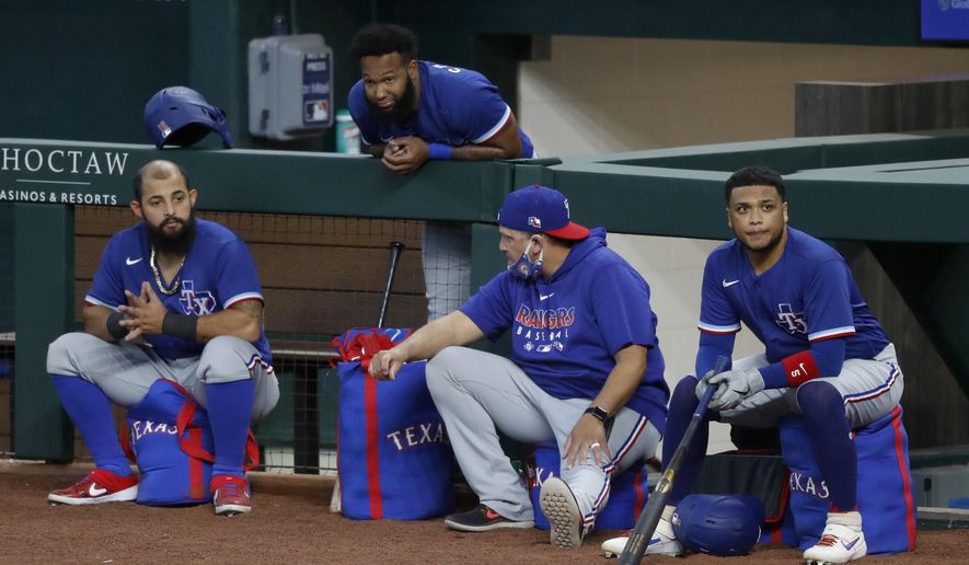 Texas Rangers' Rougned Odor, left, Danny Santana, top, catching coach Hector Ortiz and Willie Calhoun, right, participate in an intrasquad game during baseball practice at Globe Life Field in Arlington, Texas, Friday, July 10, 2020. (AP Photo/Tony Gutierrez)