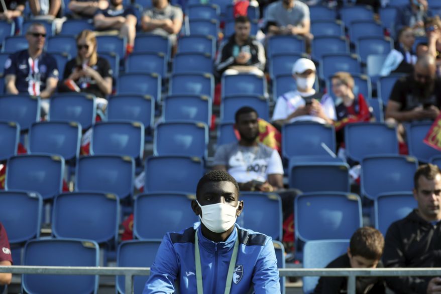 A ball carrier wears a face mask prior to the friendly soccer match between Paris Saint Germain and Le Havre, in Le Havre, western France, Sunday, July 12, 2020. For the first time since the coronavirus shut down sports and chased away spectators, Neymar, Kylian Mbappe and other soccer stars are going to play again in front of fans. (AP Photo/Thibault Camus)