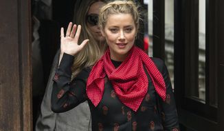 Actress Amber Heard gestures as she arrives at the High Court for a hearing in Johnny Depp&#39;s libel case, in London, Wednesday July 15, 2020. Depp is suing News Group Newspapers, publisher of The Sun, and the paper’s executive editor, Dan Wootton, over an April 2018 article that called him a “wife-beater.” The Sun’s defense relies on a total of 14 allegations by Heard of Depp’s violence. He strongly denies all of them. (Dominic Lipinski/PA via AP)
