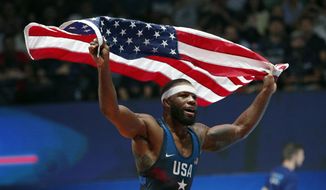 FILE - In this Saturday, Aug. 26, 2017, file photo, United States&#39; Jordan Ernest Burroughs celebrates after defeating Khetik Tsabolov, of Russia, in the men&#39;s freestyle 74-kg category during the final of the Wrestling World Cup at the Paris Bercy Arena, in Paris, France. Burroughs, the face of U.S. wrestling for nearly a decade, said Wednesday, July 15, 2020, he plans to compete another four years with the hope of finishing his career at the Paris Olympics. (AP Photo/Christophe Ena, File)