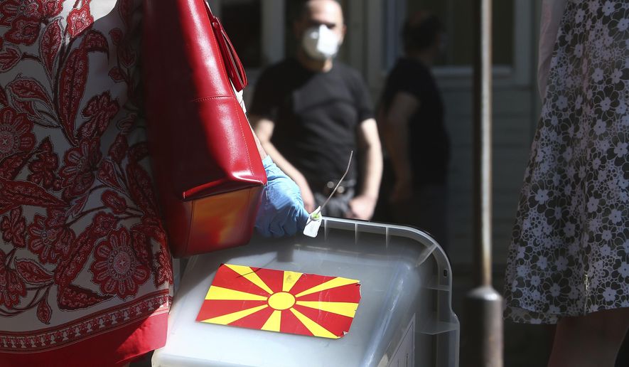 A woman carries a ballot box at a municipal election commission headquarters making final arrangements prior to visiting voters who have tested positive for COVID-19 or are in self-isolation, in Skopje, North Macedonia on Monday, July 13, 2020. North Macedonia holds its first parliamentary election under its new country name this week, with voters heading to the polls during an alarming spike of coronavirus cases in the small Balkan nation. Opinion polls in the run-up to Wednesday’s vote indicate a close race between coalitions led by the Social Democrats and the center-right opposition VMRO-DPMNE party. (AP Photo/Boris Grdanoski)