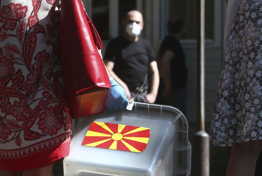 A woman carries a ballot box at a municipal election commission headquarters making final arrangements prior to visiting voters who have tested positive for COVID-19 or are in self-isolation, in Skopje, North Macedonia on Monday, July 13, 2020. North Macedonia holds its first parliamentary election under its new country name this week, with voters heading to the polls during an alarming spike of coronavirus cases in the small Balkan nation. Opinion polls in the run-up to Wednesday’s vote indicate a close race between coalitions led by the Social Democrats and the center-right opposition VMRO-DPMNE party. (AP Photo/Boris Grdanoski)