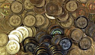 This April 3, 2013, file photo shows bitcoin tokens in Sandy, Utah. (AP Photo/Rick Bowmer, File)